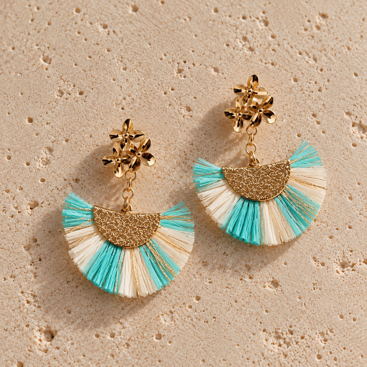 Nacre & Atlas Palma Raffia Fan Earrings in Ivory, Gold and Aqua, featuring textured raffia fans with aqua accents, polished gold floral details and a statement drop design.